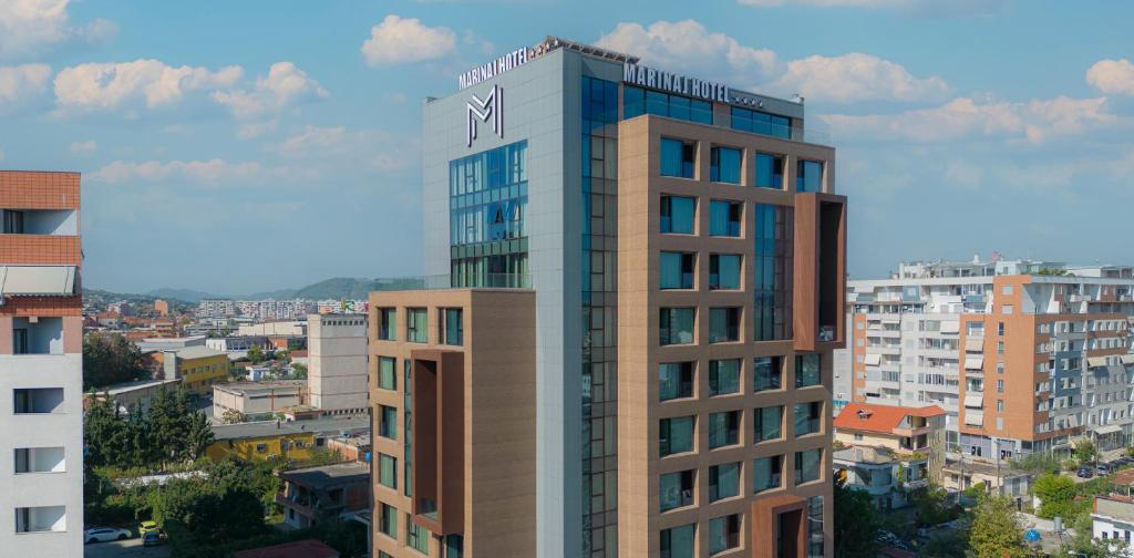 ein hohes Gebäude mit einer Uhr darüber in der Unterkunft Marinaj Hotel in Tirana