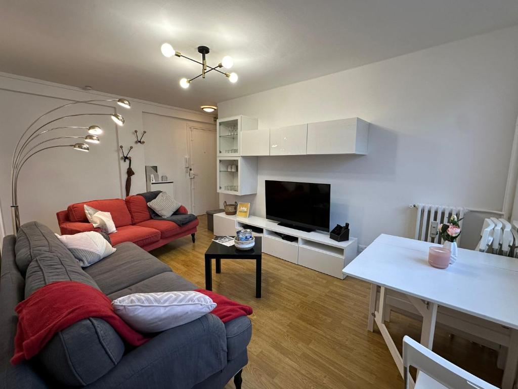 een woonkamer met een bank en een tafel bij 4 Beds Apartment close PARIS center in Vanves