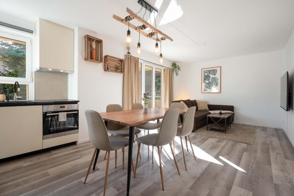 a kitchen and dining room with a wooden table and chairs at Moderne Wohnung mit Parkplatz in Ostermundigen