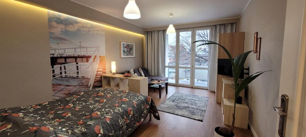 um quarto com uma cama, uma secretária e uma televisão em Apartament na Heweliusza em Gdańsk