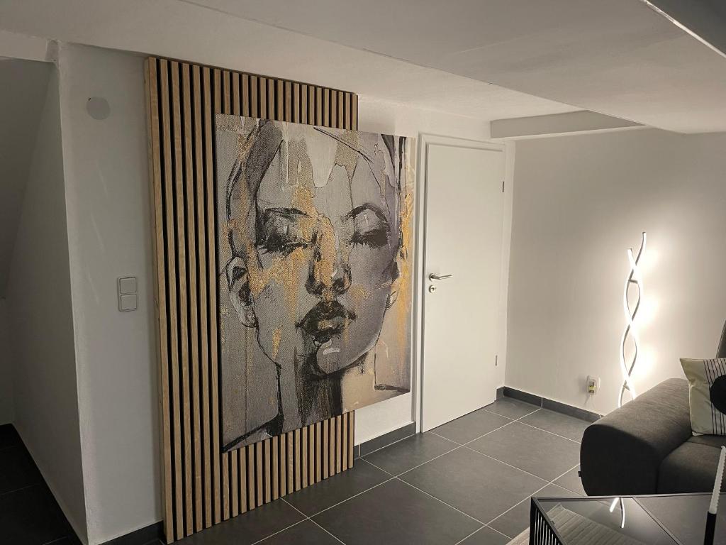 una pintura de una mujer en una pared en una sala de estar en Stilvolles Designappartment mit Terasse & Garten im idylischem Bindlach, en Bindlach