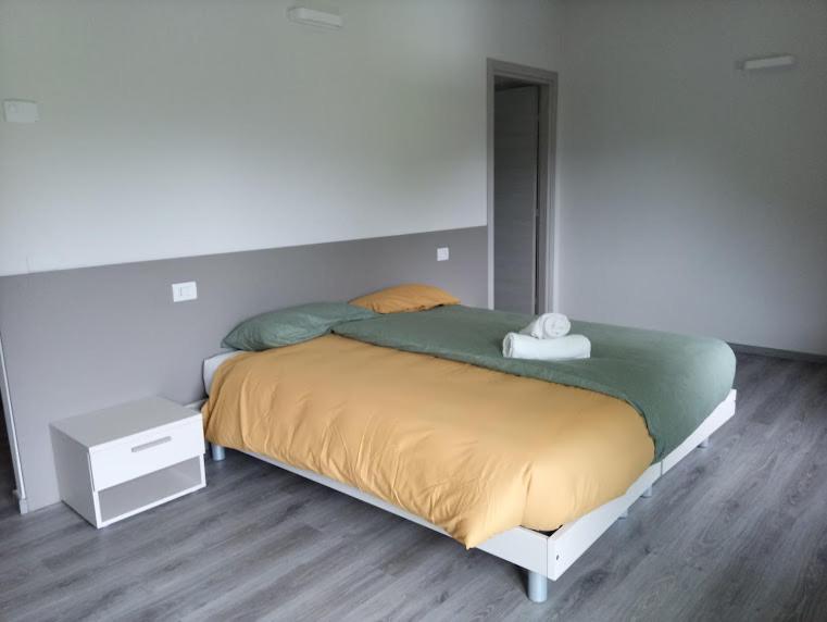 een slaapkamer met een groot bed en een wit nachtkastje bij Terra e Radici_Castanea in Torre di Santa Maria