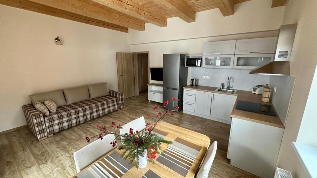 a kitchen and a living room with a couch and a table at Apartmány LehotSKI Guest House in Pavčina Lehota