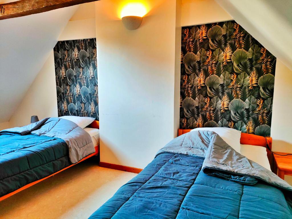 1 dormitorio con 2 camas y un mural en la pared en Gîte 3 étoiles - Spacieux et confortable ancienne grange rénovée - Cantal Emotions Valette - Auvergne, en Valette