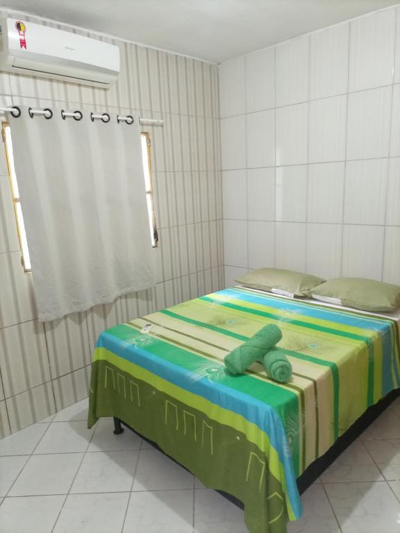 um quarto com uma cama com um cobertor verde em Casa Eco Via Norte - MCZ em Maceió