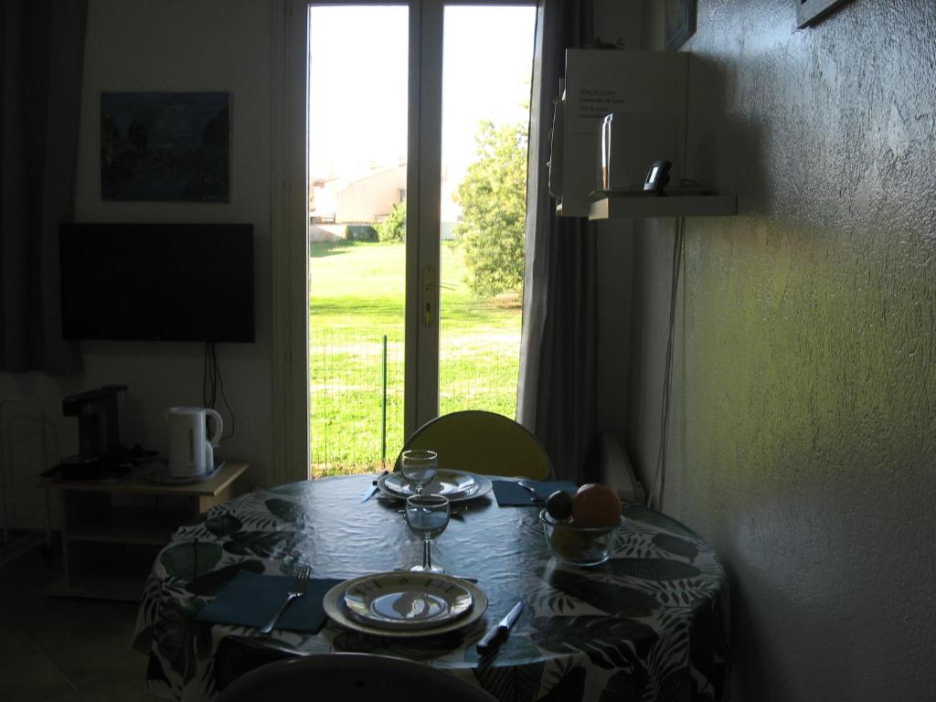 - une table dans une chambre avec vue sur une fenêtre dans l'établissement lumineux agréable T2 DE 32M2, à La Londe-les-Maures