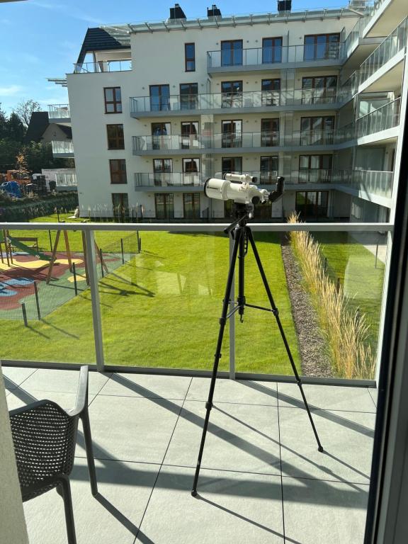 una cámara en un trípode en un balcón con un edificio en Mountains & SPA Apartament Zakopiański en Zakopane
