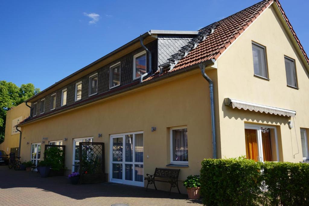una casa gialla con una panchina davanti di Maisonetten Apartment a Rheinsberg