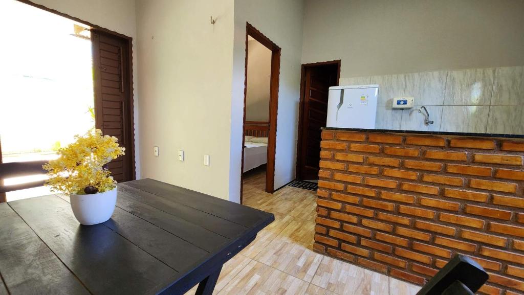 a kitchen with a table and a brick wall at Suítes Green Village Flecheiras in Flecheiras