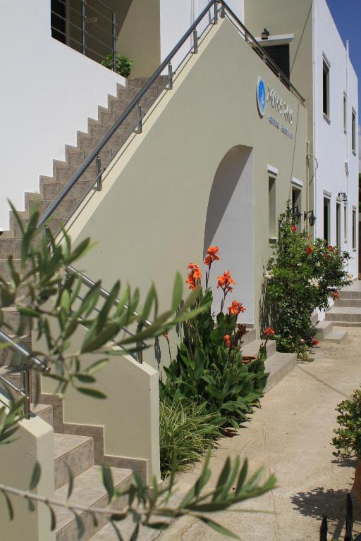 a building with stairs and flowers in front of it at Xenios Zeus Apartments in Kissamos