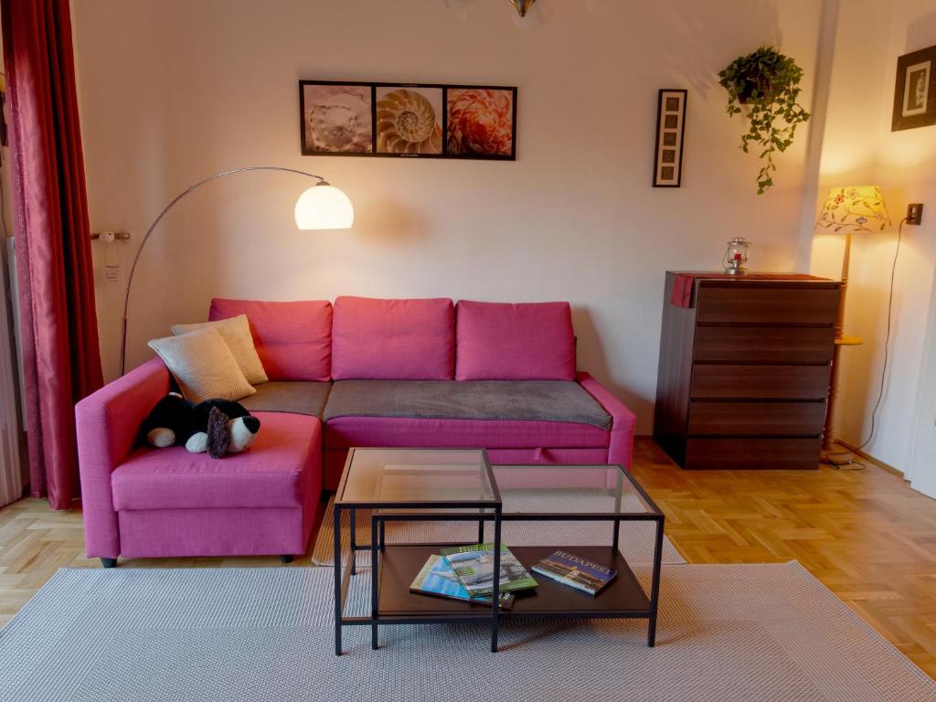 ブダペストにあるFamily Buda Apartmentのリビングルーム(ピンクのソファ、テーブル付)