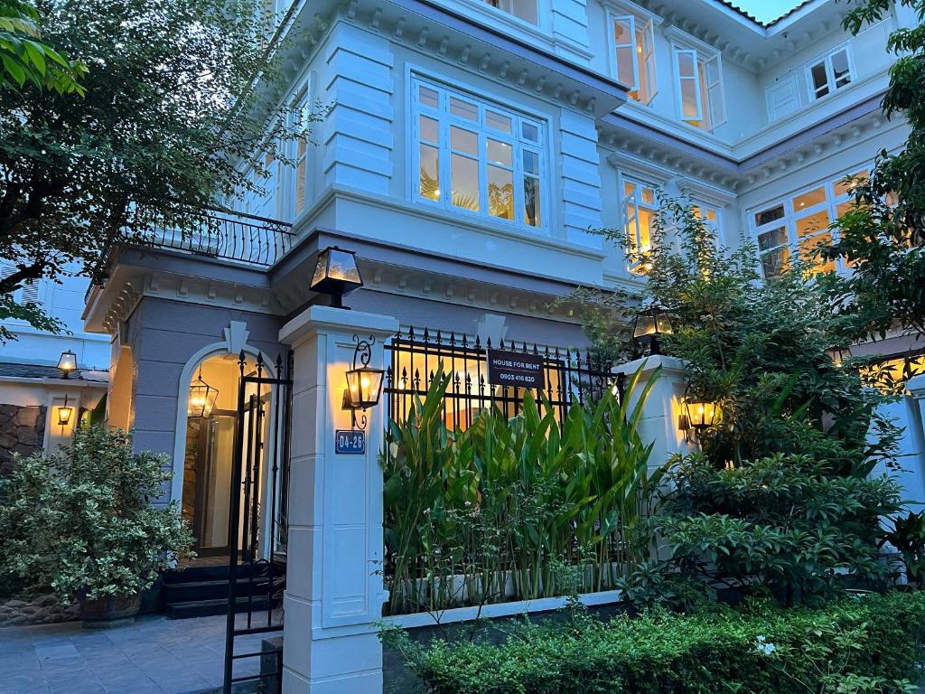 a blue house with a gate in front of it at Luxury Garden Villa with premium spa 4 bedrooms Ciputra in Hanoi