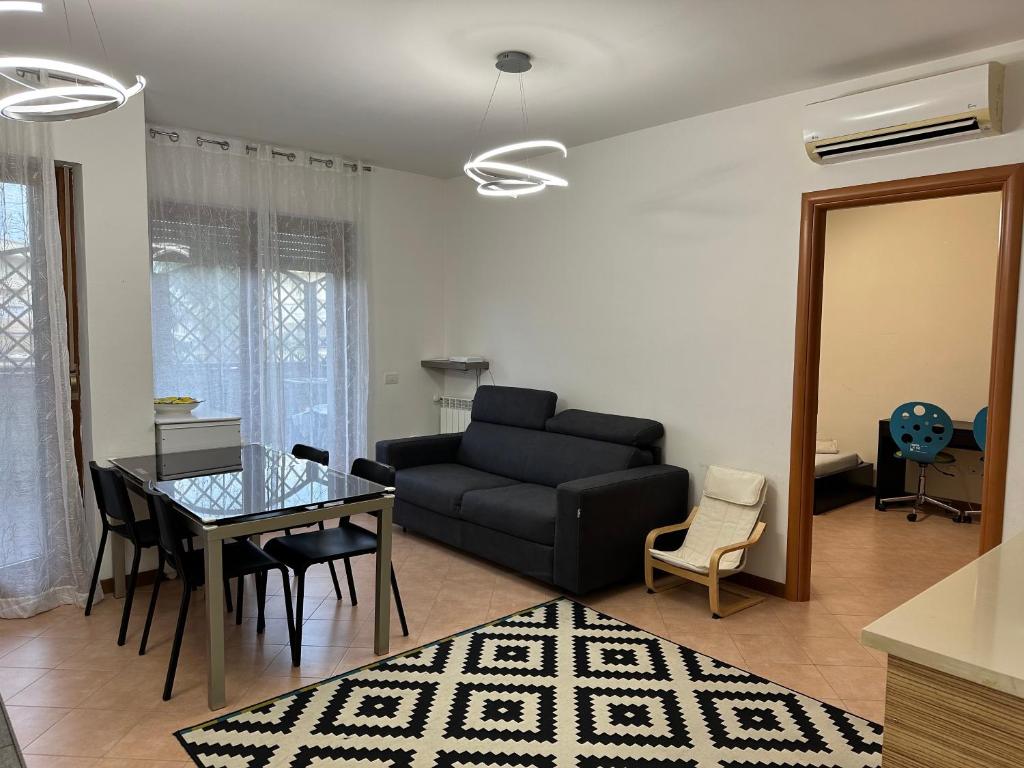 a living room with a black couch and a table at Suite Tania in Fregene