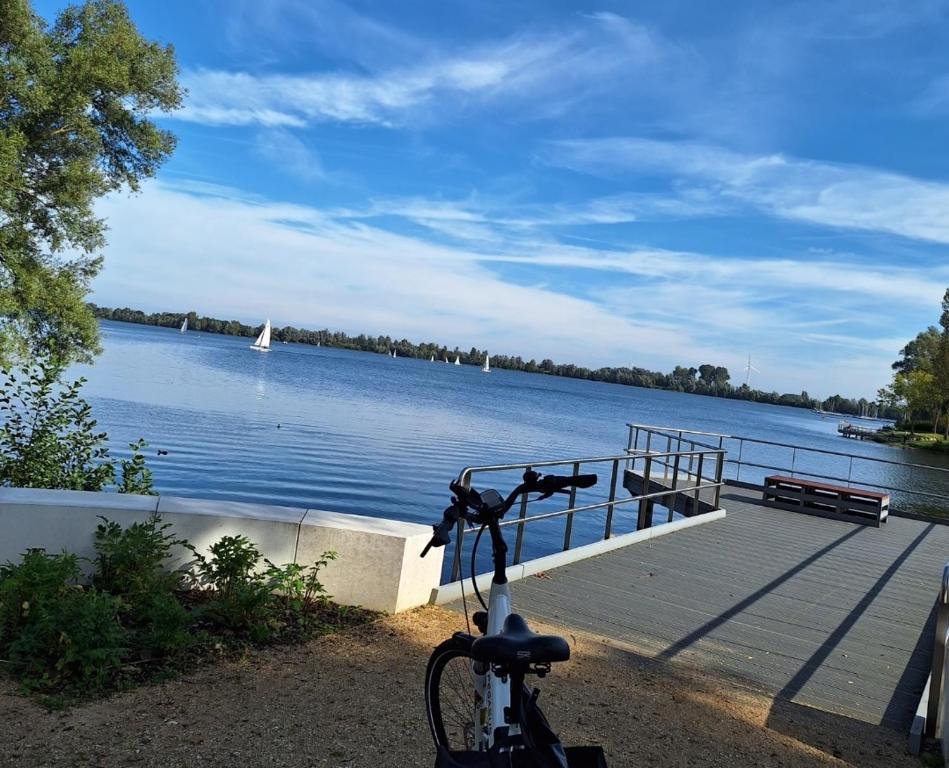 una bicicleta estacionada junto a un muelle con un cuerpo de agua en Parva Domus, en Xanten