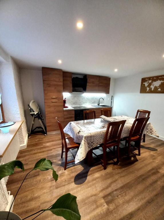 une salle à manger avec une table et des chaises et une cuisine dans l'établissement La petite ferme, à La Chapelle