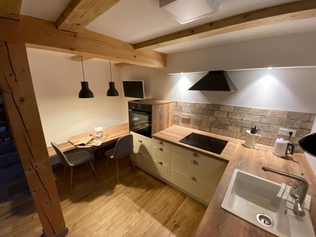 een keuken met een tafel en een aanrechtblad bij FachwerkLiebe in Quedlinburg