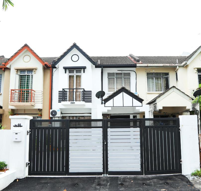 uma casa com um portão preto e branco em Homestay Dsunway em Petaling Jaya