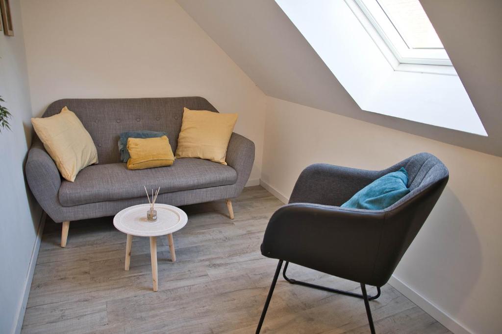 un salon avec un canapé et une chaise dans l'établissement Coeur Joigny nature zen 3, à Joigny