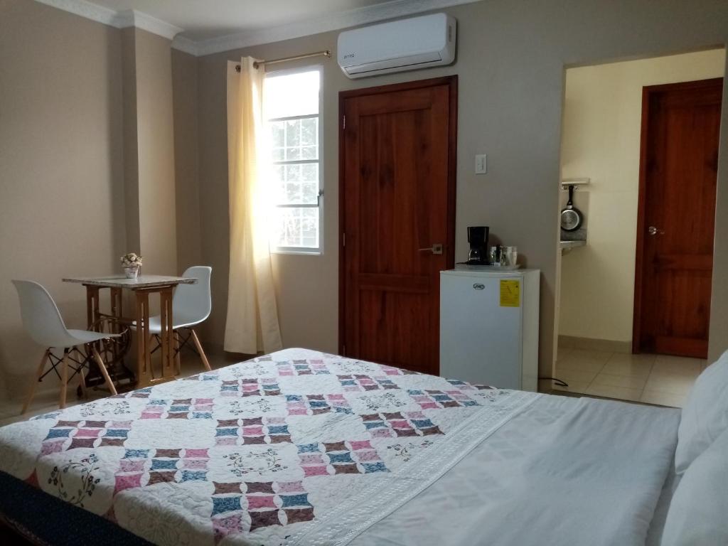 1 dormitorio con 1 cama con edredón en Suite con estacionamiento, en Machala