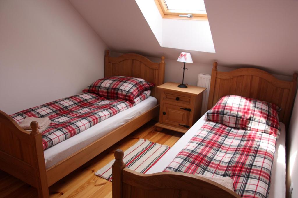 two beds in a small bedroom with a window at Storczykowe Wzgórze in Paszowice