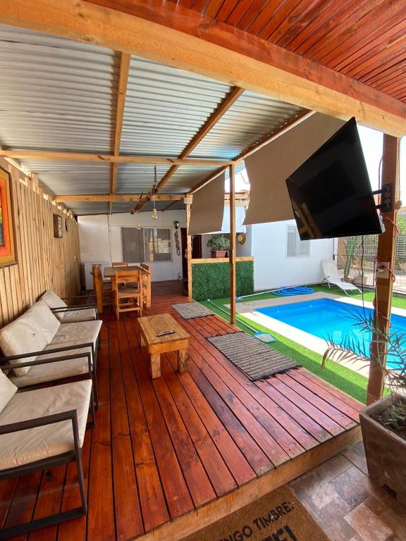 um pátio com uma televisão e uma piscina em Casa descanso lluta em Arica