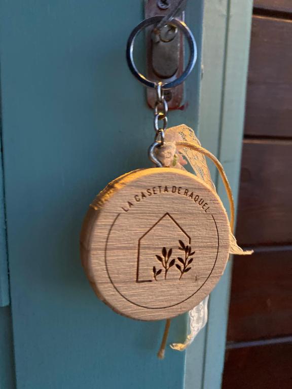 a wooden key chain with a house on it at La Caseta de Raquel in Oristá