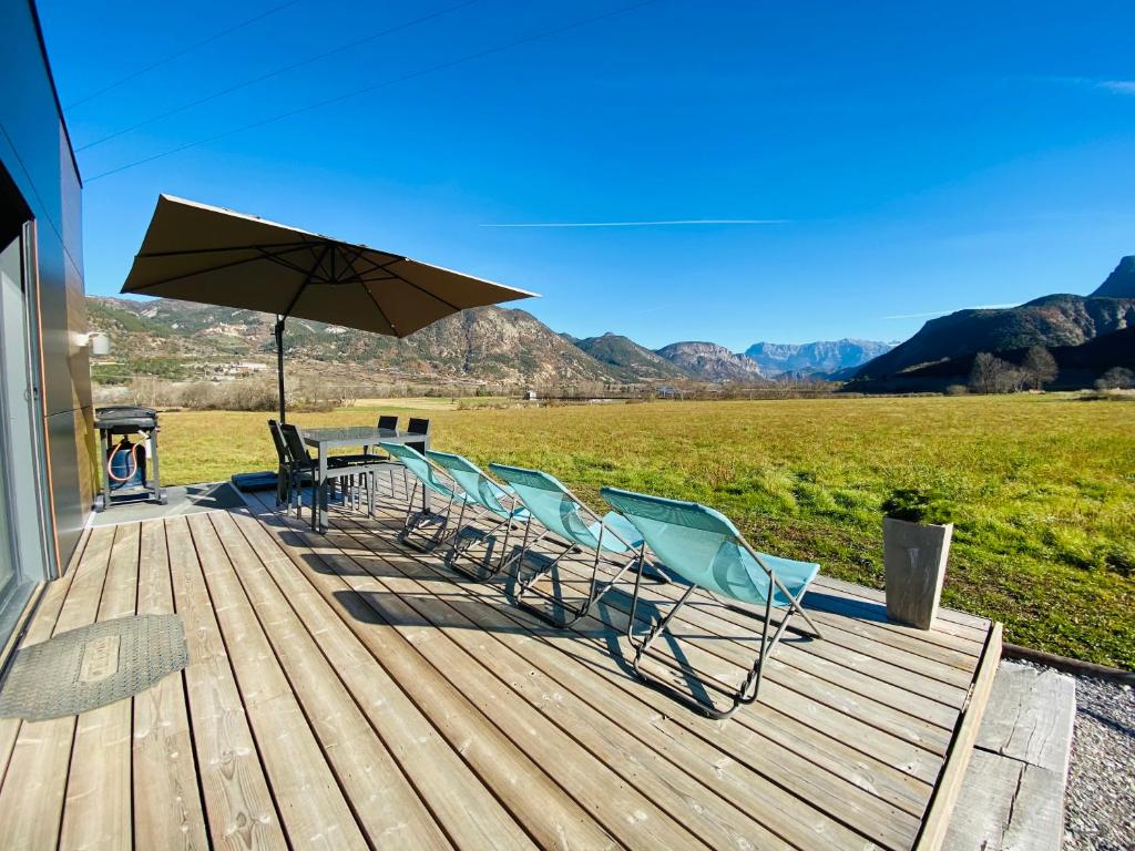 leżak z krzesłami, stół i parasol w obiekcie Charmant logement entre Lac et Montagne w mieście Rochebrune