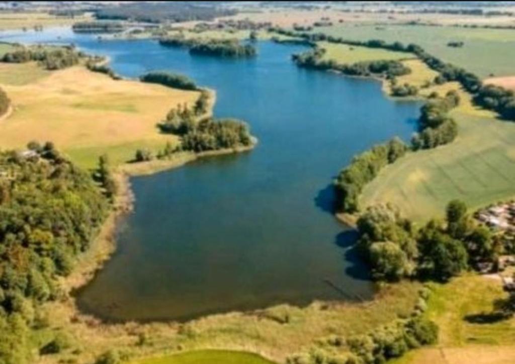 an aerial view of a lake with trees and water at Wohnmobilstellplatz in der Mecklenburgischen Seenplatte in Carpin