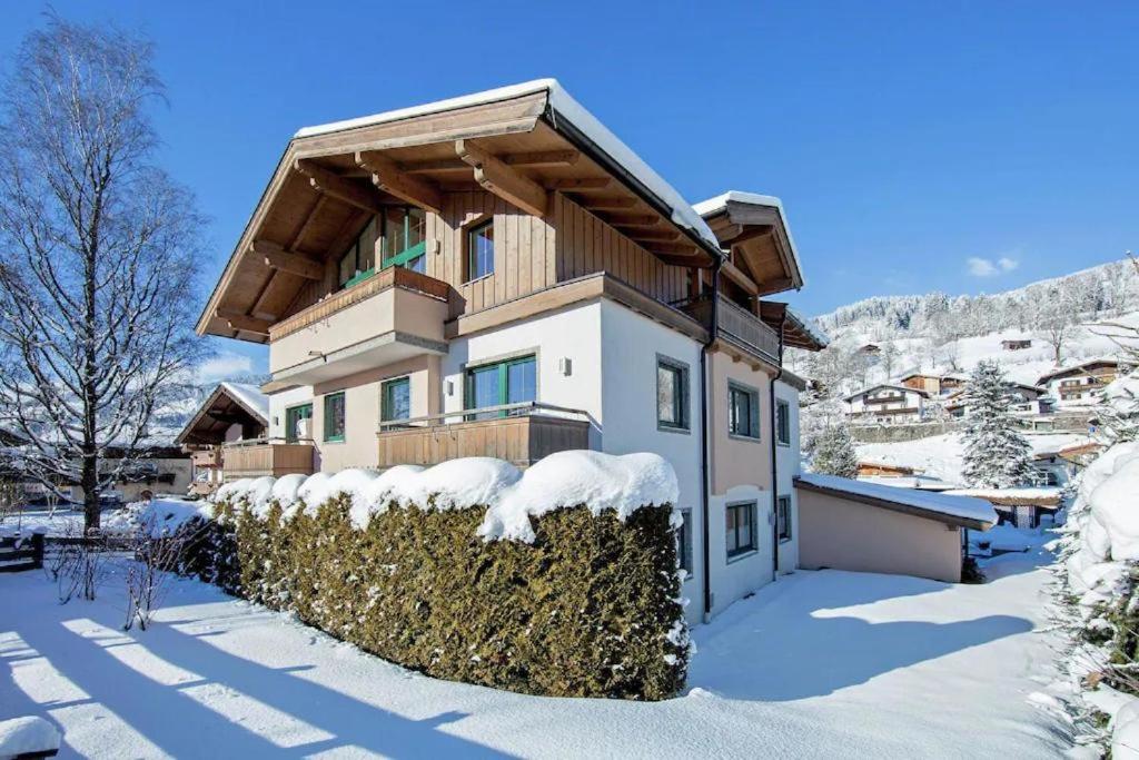 a house in the snow with a hedge at Ferienwohnung Victoria in Brixen im Thale