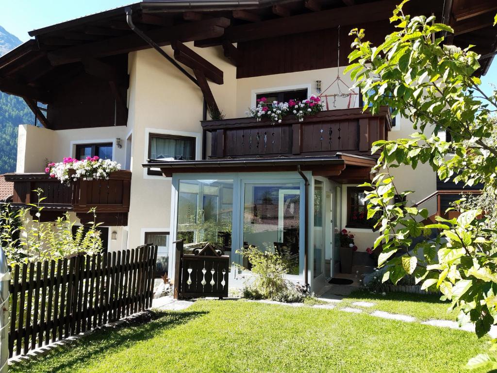 une maison avec un balcon fleuri dans l'établissement Ferienwohnung Eva, à Längenfeld