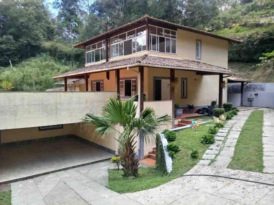 a house with a palm tree in front of it at Casa em Teresopolis in Teresópolis