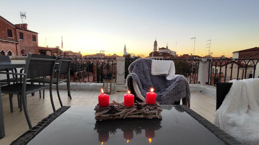 - une table avec trois bougies sur le balcon dans l'établissement VENICE HOLIDAY TERRACE, à Venise