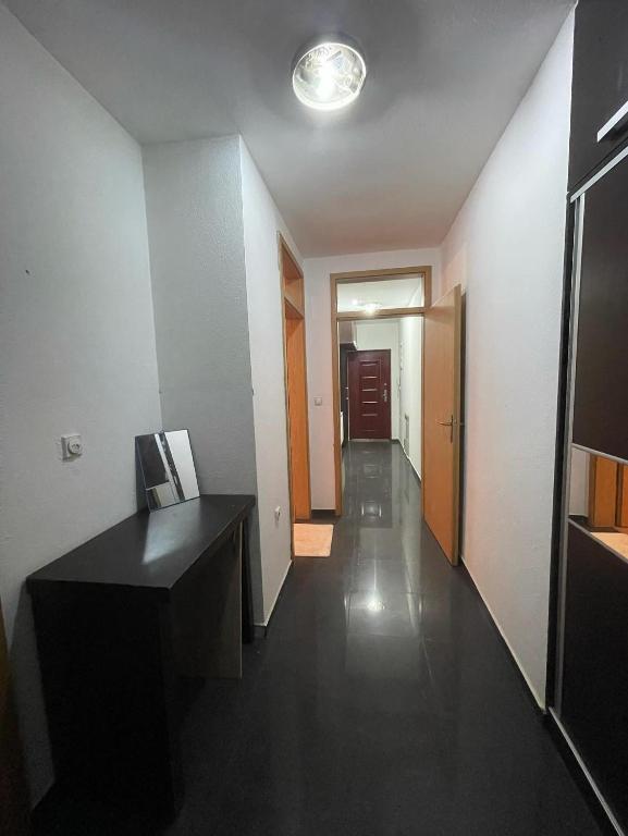 a hallway with a black desk and a hallway with a door at Erion’s apartament in Kosovo Polje