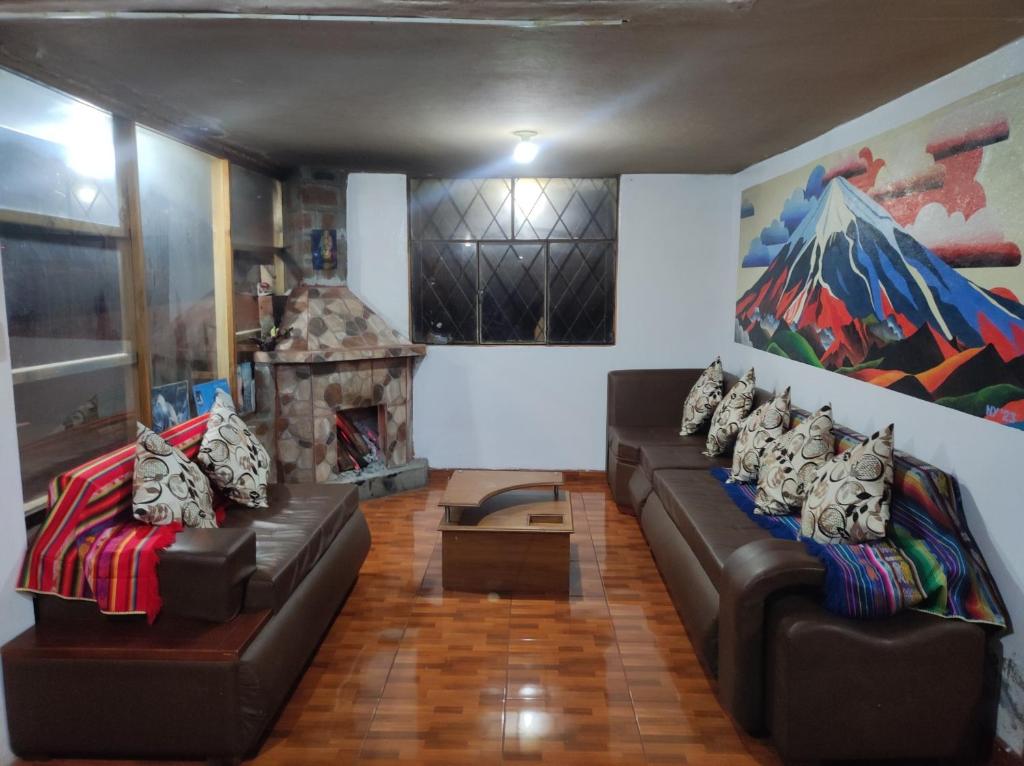 uma sala de estar com dois sofás de couro e uma lareira em Ilinizas Wasi Hospedaje-Restaurante em Machachi