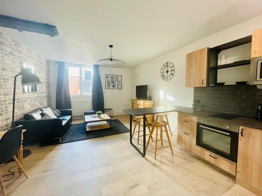 une cuisine et un salon avec un canapé et une table dans l'établissement Style Loft Chic : T2 avec Chambre Parentale -Top Séjour Arras, à Arras