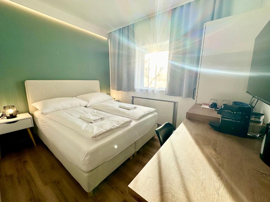 a bedroom with a white bed and a window at SmartRooms24 in Villach