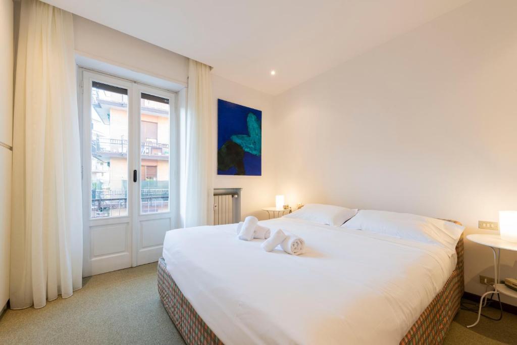 sypialnia z dużym białym łóżkiem i oknem w obiekcie Residenza Astra w Weronie