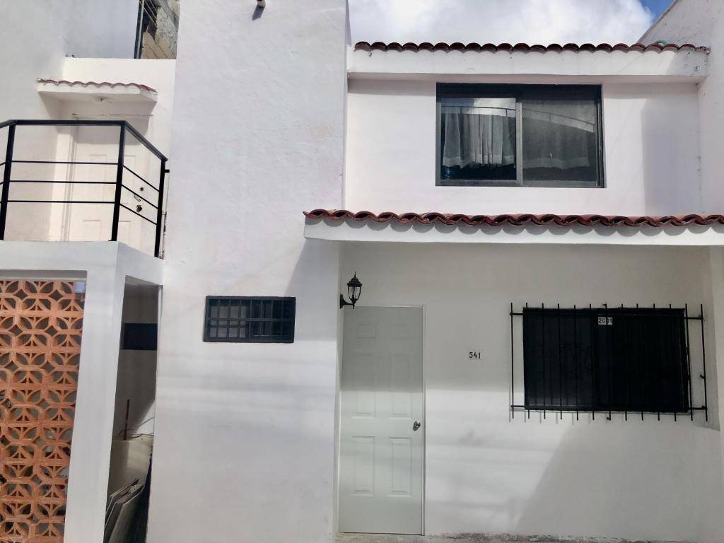 a white house with a door and a window at Depa Lunero in Cancún