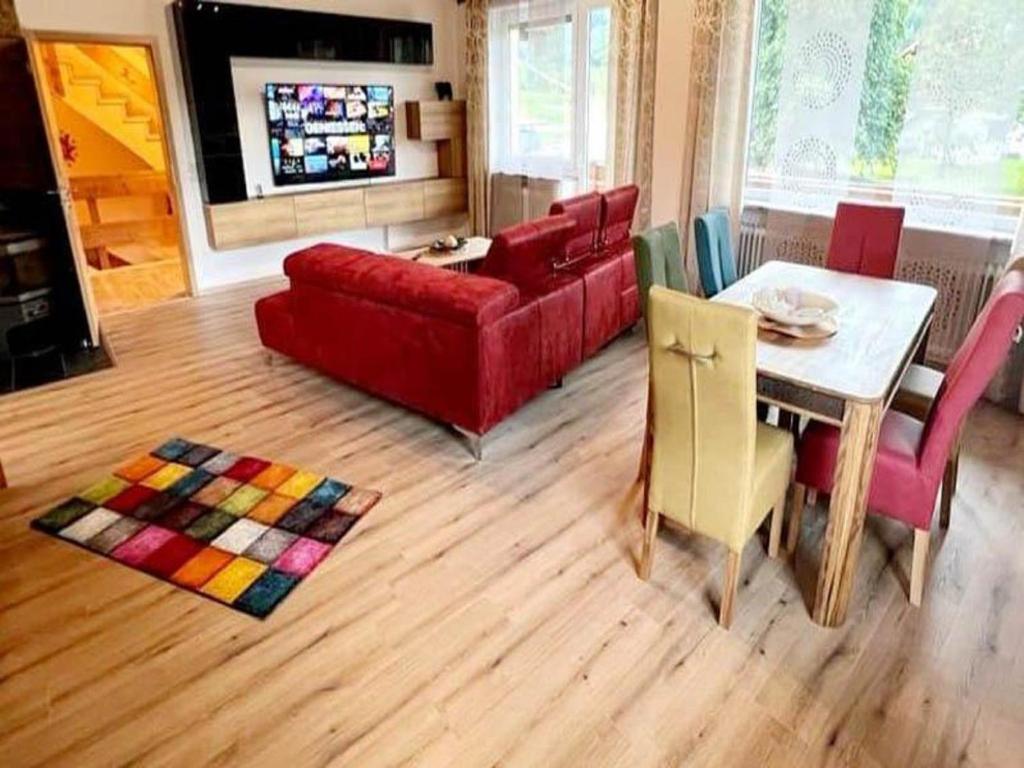 ein Wohnzimmer mit einem roten Sofa und einem Tisch in der Unterkunft Ferienhaus Lieblingsplatz in Blaibach