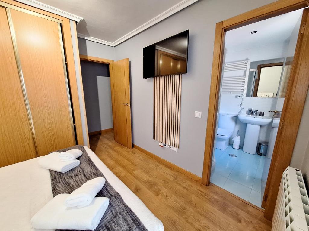 Habitación pequeña con cama y baño. en APARTAMENTO TURISTICO EL CANALIZO, en Candelario