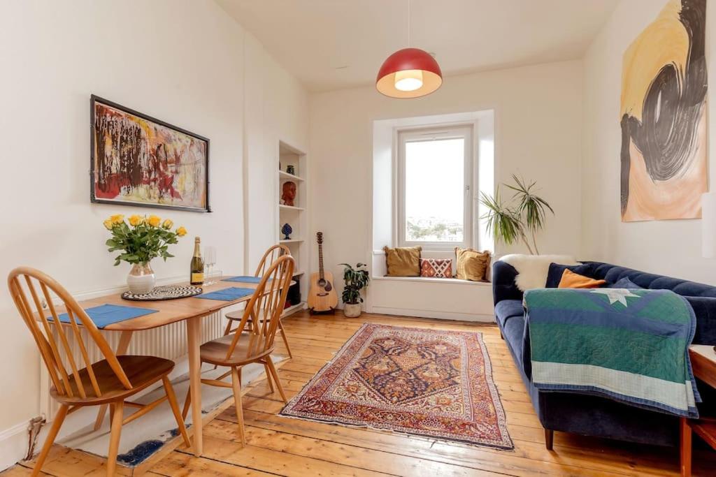 a living room with a table and a blue couch at Vibrant and Spacious 2BD flat for 4 in Edinburgh in Edinburgh