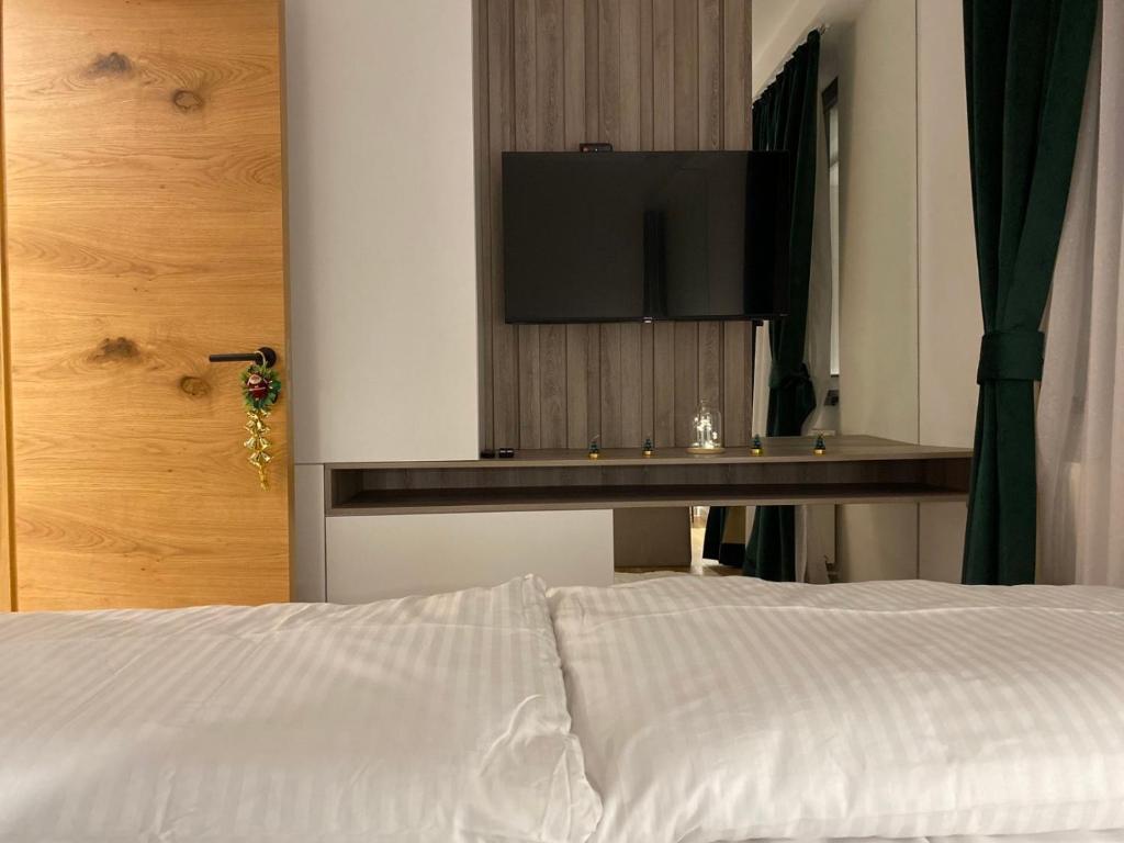 a bedroom with a bed with a television on the wall at Apartman 305 Zlatni Javor in Jahorina