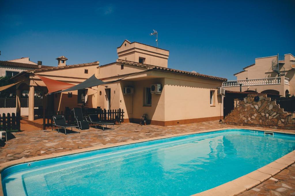 a swimming pool in front of a house at Casa Tati in Sant Pere Pescador