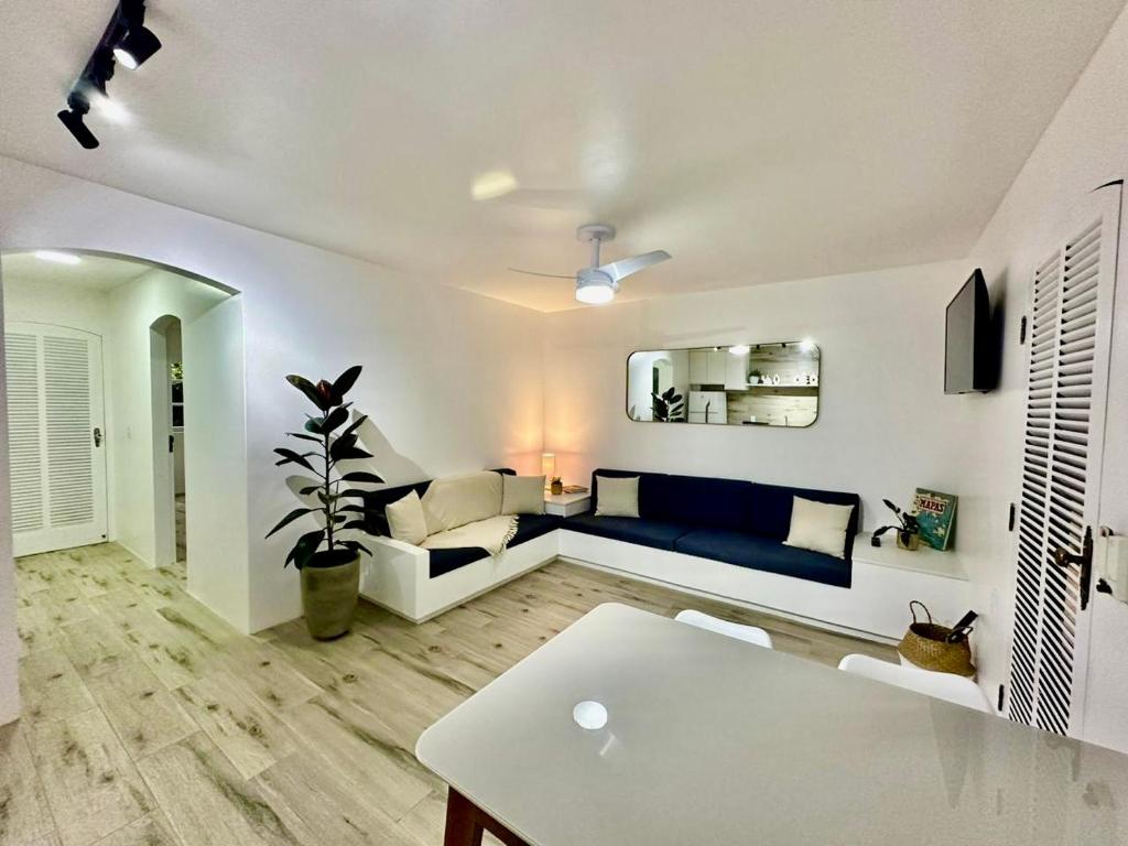 ein Wohnzimmer mit einem Sofa und einem Tisch in der Unterkunft Apartamento estilo Chalé com piscina in Ubatuba