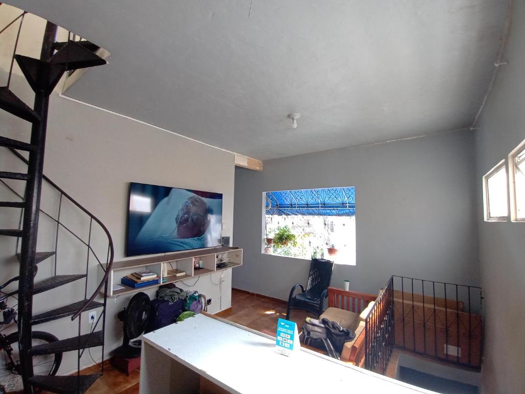uma sala de estar com uma televisão de ecrã plano na parede em Discovery hostel em Manaus