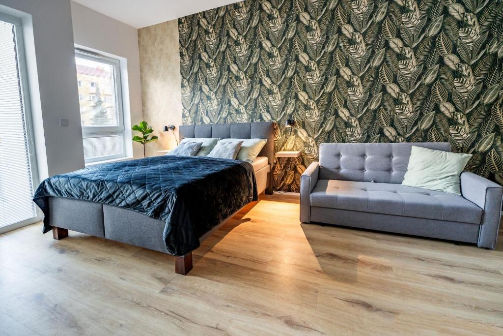 1 dormitorio con 1 cama y 1 sofá en Wolkerovka Apartment 2, en Olomouc