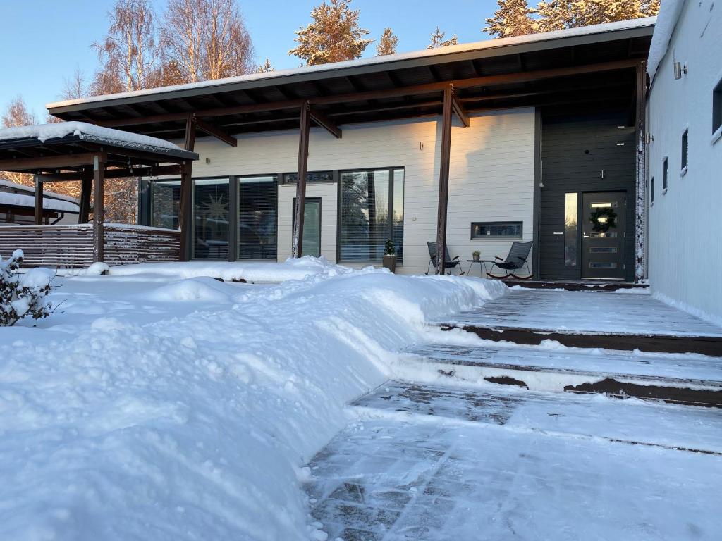 una casa con un mucchio di neve davanti di Villa Harmony a Rovaniemi