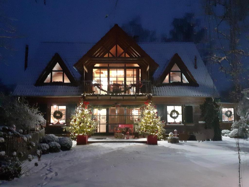 ein Haus mit Weihnachtsbäumen im Schnee in der Unterkunft Cornelia Kolpak-Krieger in Pegnitz