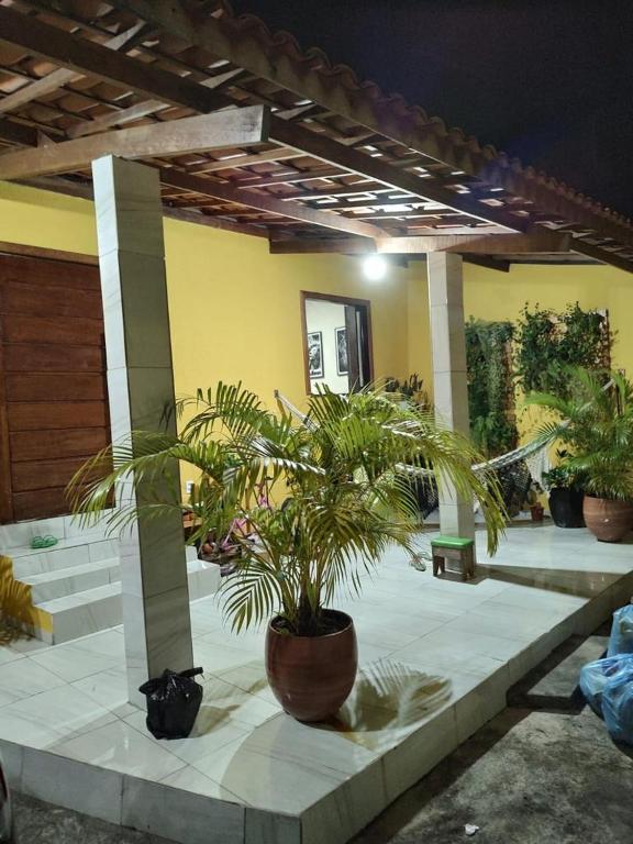 eine Terrasse mit Topfpflanzen in einem Gebäude in der Unterkunft Casa com piscina in Camaçari
