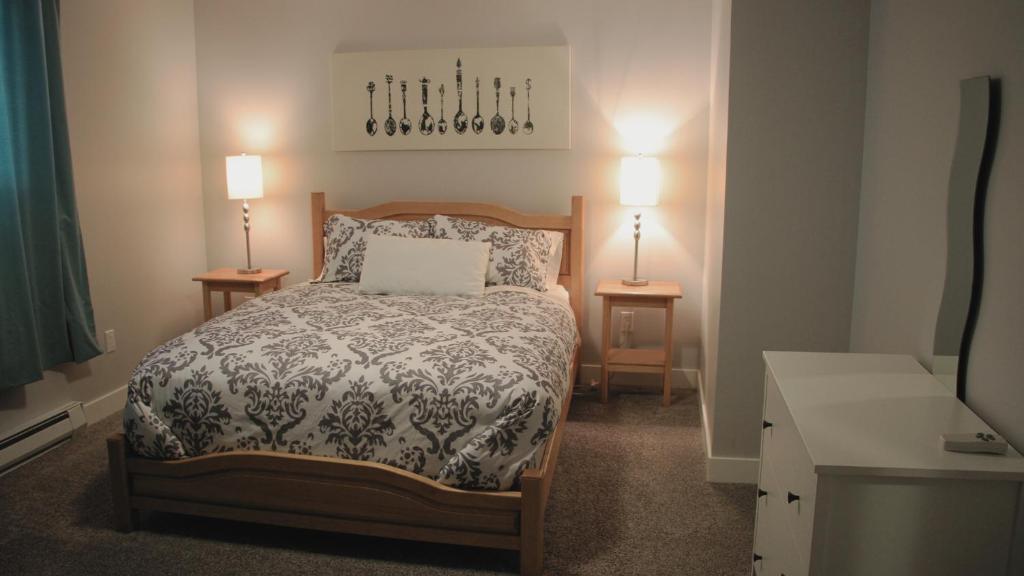 1 dormitorio pequeño con 1 cama y 2 mesitas de noche en Stoneshire Guesthouse, en Clearwater